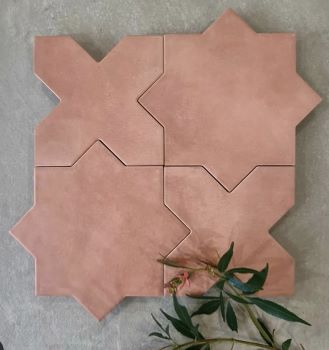 Terracotta pink star and cross interlocking tiles laid on a stone bench