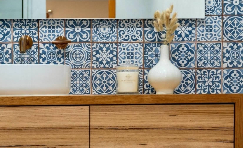 Blue and white Moroccan pattern splashback behind a timber vanity