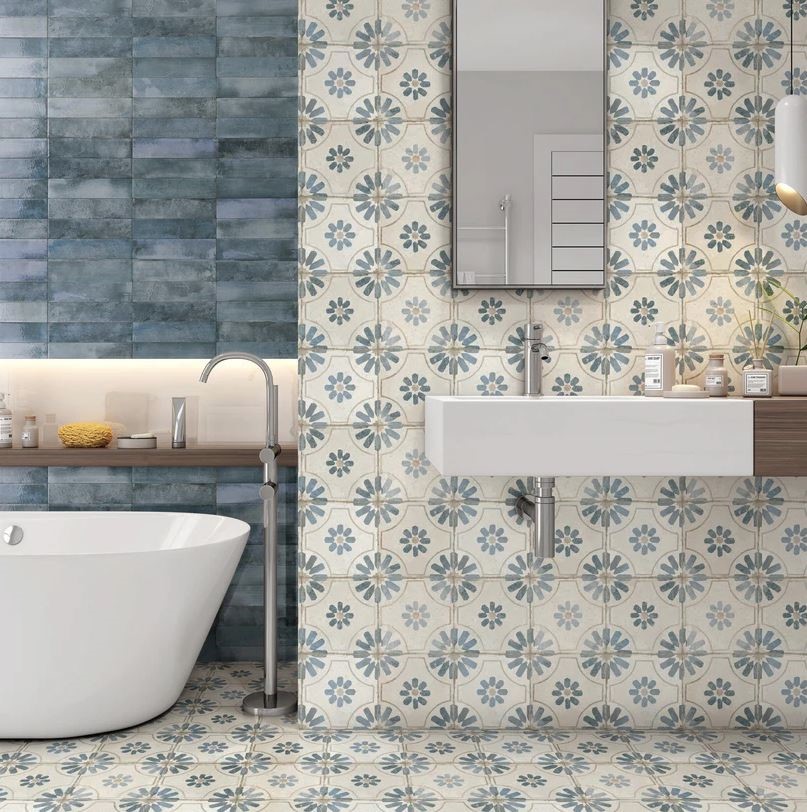Bathroom with KC889 blue pattern tiles on the floor and walls, a wall-hung basin and freestanding bath