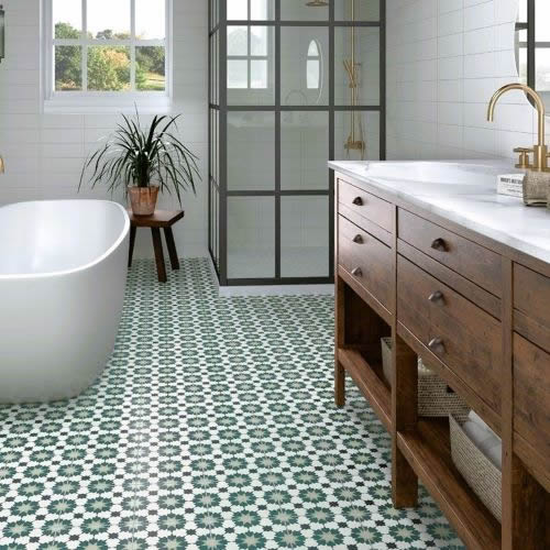 Farmhouse bathroom with green star pattern floor tiles, freestanding bath, timber vanity and black framed shower screen