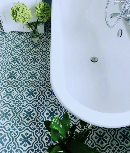 Freestanding bath on teal heritage pattern bathroom floor tiles