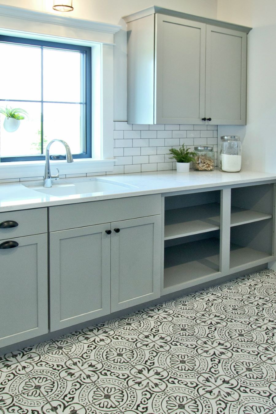 Sage green kitchen with black and white pattern floor tiles