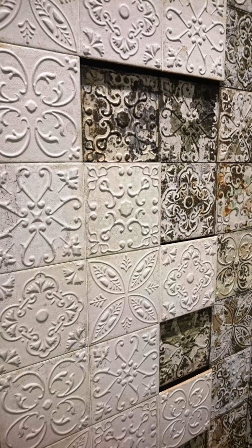 White embossed pressed metal look wall tiles mixed with aged patterned tiles