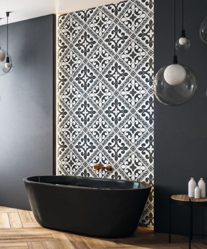 Bathroom feature wall in black and white encaustic look pattern tiles behind a black freestanding bath